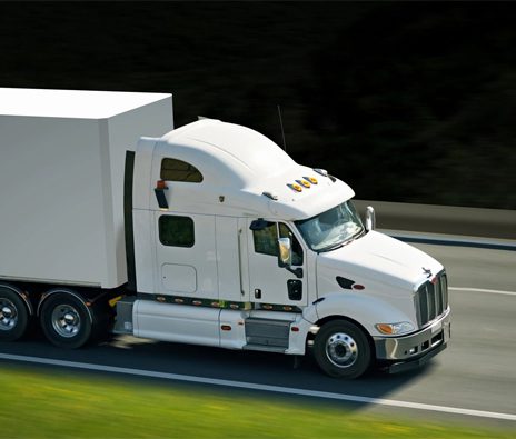 A white semi truck driving down the road.