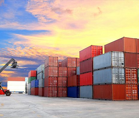 A large cargo container yard with a plane in the background.