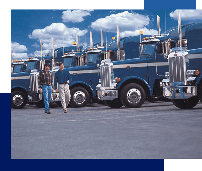 A row of large trucks parked in front of each other.