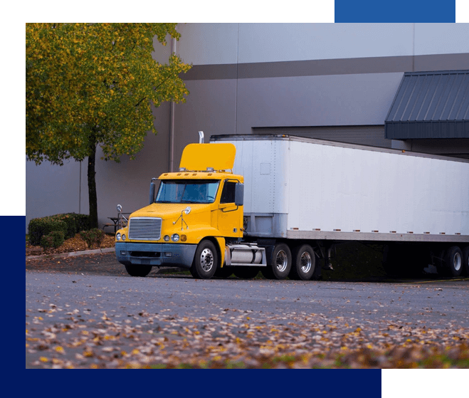 A yellow and white truck parked in front of a building.