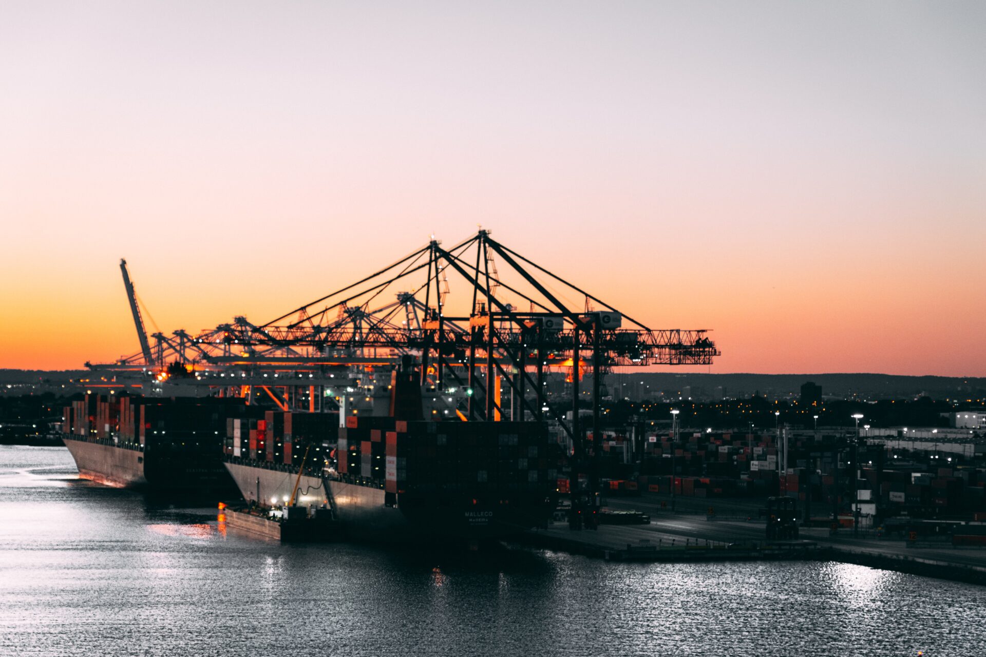 A large ship in the water at sunset.